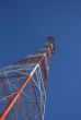 Red and white power tower in the blue sky