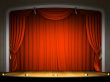 Empty stage with red curtain in expectation of performance
