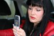woman is sms by mobile phone in a car