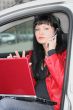 woman is calling by mobile phone and working at laptop in a car