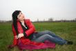 black head woman is sitting on a Plaid in park grass