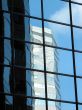 Corporate tower reflecting another office building and the sky