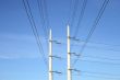 Two white electricity pylons and stretching wires