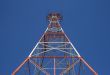 Red triangular power tower in the blue sky