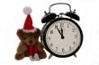 teddy bear in christmas red cap and old alarm clock