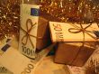 Two golden christmas gift boxes with money