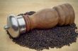 Pepper Mill in pepper on wooden cutting board