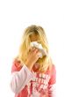 Young blond girl sneezing in the handkerchief