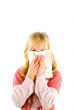 Young blond girl sneezing in the handkerchief