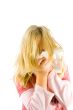 Young blond girl sneezing in the handkerchief