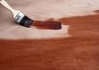 Painting a wooden surface with a brush