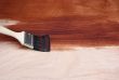 Paint brush painting a wooden surface