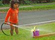 Little girl playing with water in summer day.