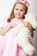 Nice young girl in pink on light background with teddy bear