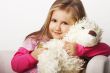 Nice young girl in pink on light background with teddy bear