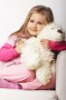 Nice young girl in pink on light background with teddy bear