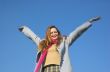 The happy girl on a background of the blue sky