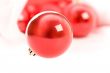 Red christmas balls in Santa hat on white
