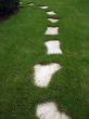 Road of white paving stones on a green lawn