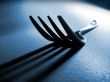 Fork tines and shadow on textured surface
