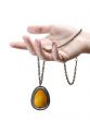 A hand with an amber pendant  isolated