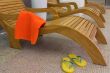 sunbed with orange towel with sandals