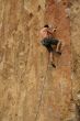 Bare back climber clinging to rock face