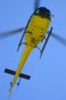 Yellow helicopter in blue sky