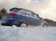 blue car is slipping at snow cavered lake