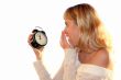 Young blond woman show time on alarm clock.