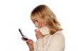 Young blond woman sms by mobile phone.
