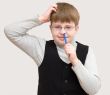 schoolboy picks one`s nose