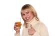 Smiling girl with Glass of juice and good idea gesture