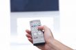 Hand with remote control and tv set