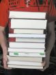 man is holding a stack of books