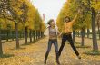 Two girls jump in autumn park