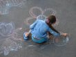female child drawing picture with chalk