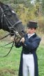equestrian female holds black stallion