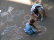 two female kids painting picture with chalk