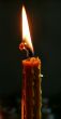 Alone candle flame upon black background