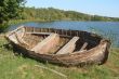 ruined vintage wooden boat on riverside