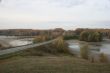 wide field with river uder cloudy deep blue sky