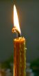 Alone candle flame upon black background