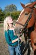 Blond female with brown horse close-up portrait
