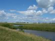 summer field with river uder cloudy deep sky