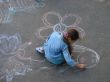 female child drawing picture with chalk