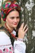 Young lady in Ukrainian costume near birch