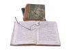 The open ancient book with glasses laying on it on a background