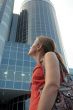The girl looks at a high building