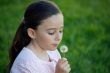 Girl blowing dandelion